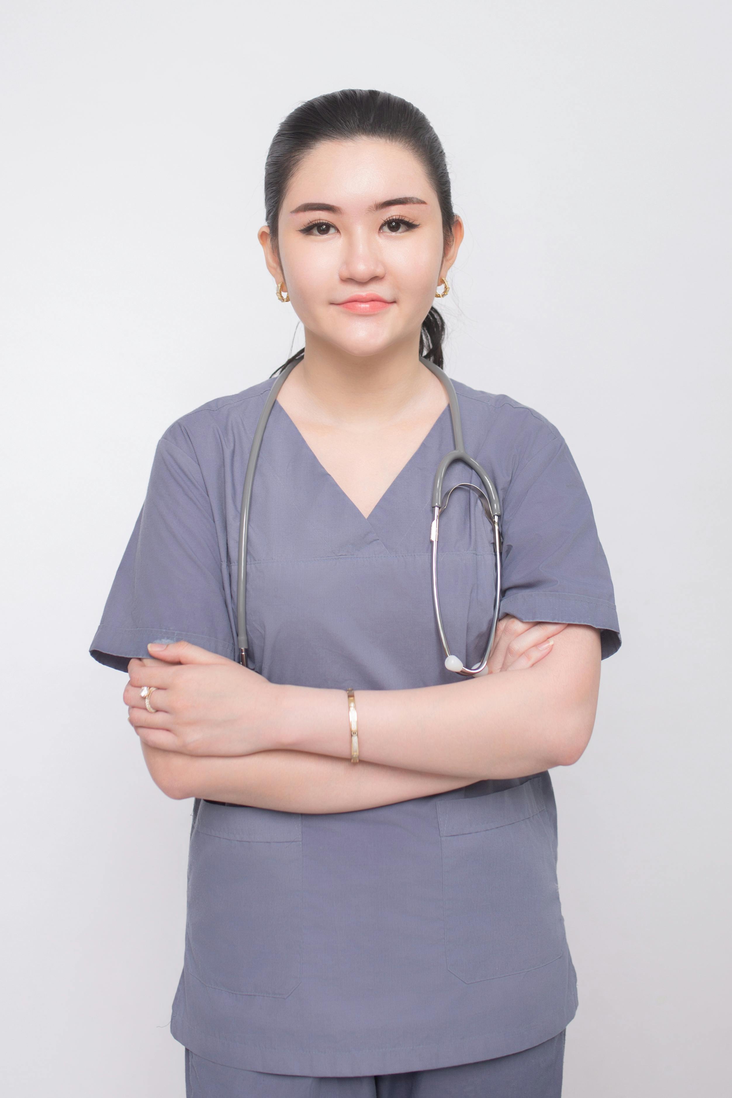 attractive young nurse holding clipboard with colleagues sitting at table on background
